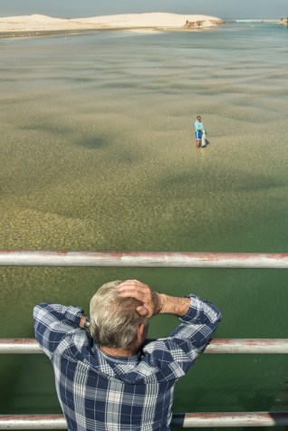 Mientras un hombre esta en el agua con la red, desde el puente, la voz de la experiencia le dirige para  dar con la presa.