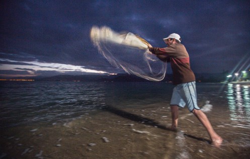Xexeo lanzando la red de mano desde la playa.