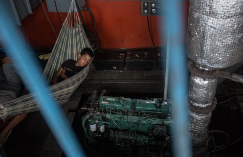 Uno de los miembros de la tripulación descansa al lado del ruidoso motor de la nave que nos lleva. Todas las noches han de hacer turnos para alumbrar el río y no chocar con las islas de arena que se forman y evitar ser asaltados.