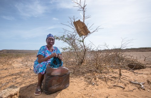 Leticia pertenece a la etnia Wayuu, y mientras teje una mochila espera a algun coche que la lleve al Pilón de Azucar para vender sus artesanias.