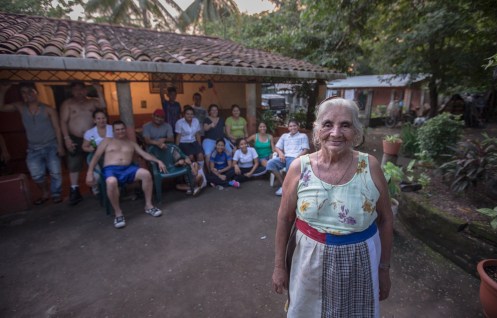 Amanda posa con parte de su familia detrás en su casa.