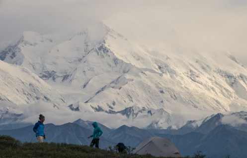Bea y Alvaro montan la tienda de campaña frente a las inmensas montañas.